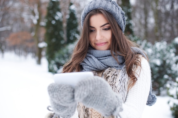 Бесплатное фото Молодая женщина с мобильным телефоном зимой