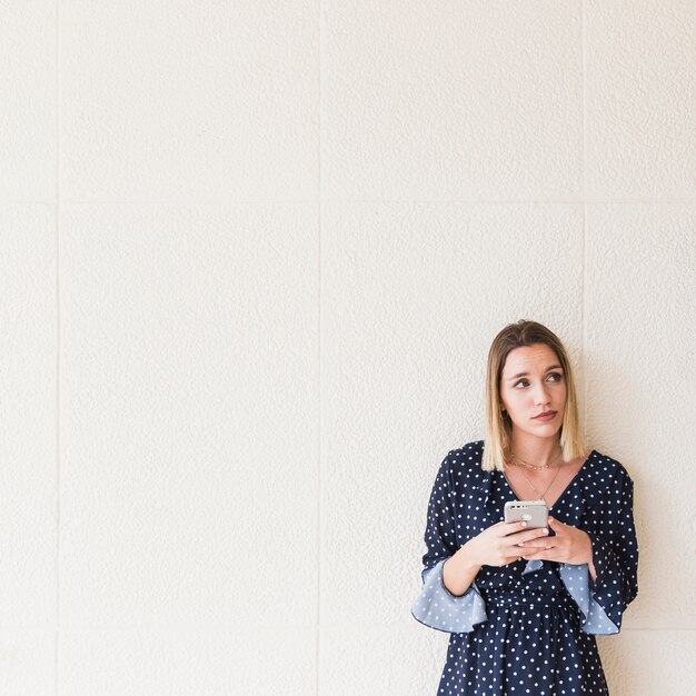 Young woman with mobile phone looking away