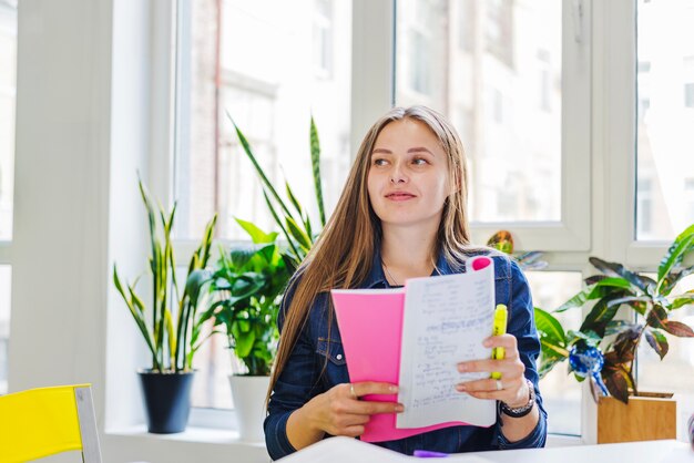 Young woman with notepad looking away