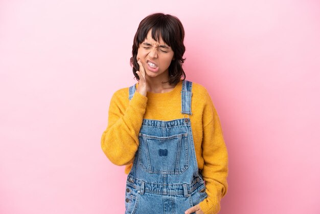 Young woman with overalls isolated background with toothache