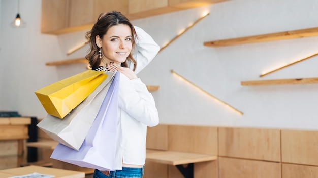 Young woman with paper bags in cafe