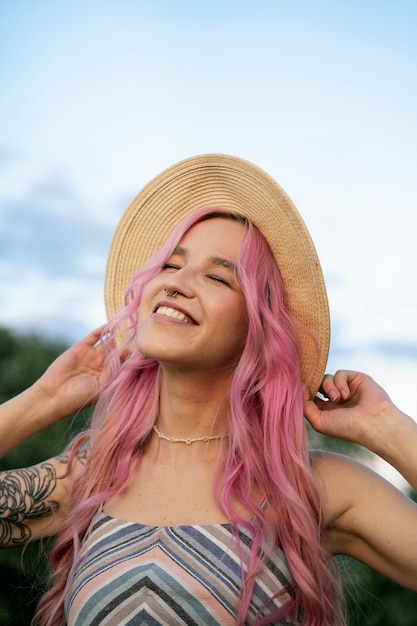 Foto gratuita giovane donna con capelli rosa sorridente