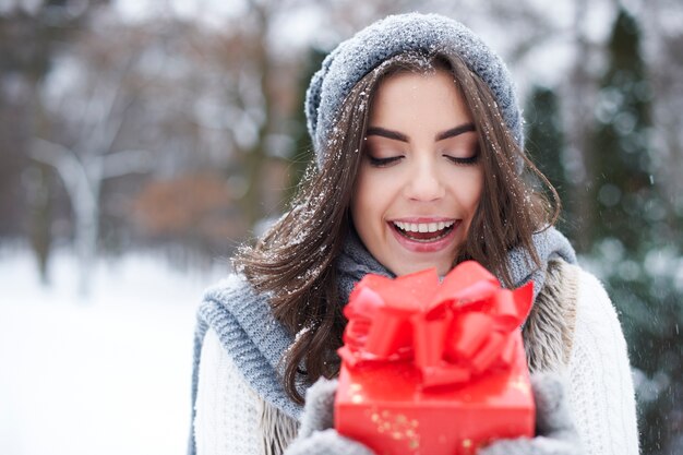 Молодая женщина с подарком зимой