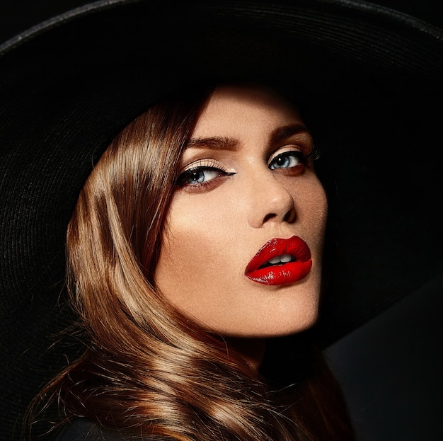 Young woman with red lips and black hat