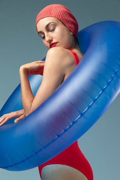 赤い水着と浮き輪を持つ若い女性
