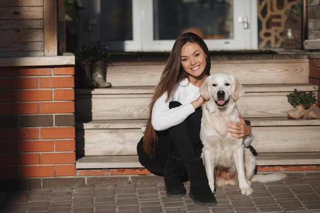 Free photo young woman with retriever dog outdoor