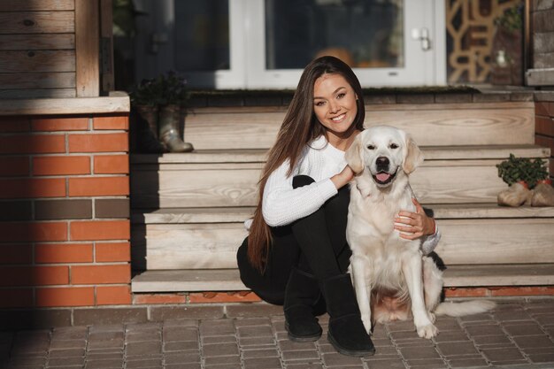 屋外のレトリバー犬と若い女性