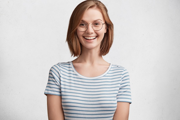 Молодая женщина в круглых очках и полосатой футболке