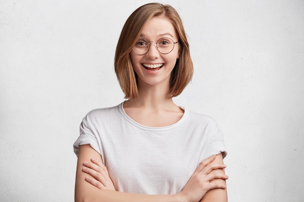 Giovane donna con occhiali rotondi e maglietta bianca