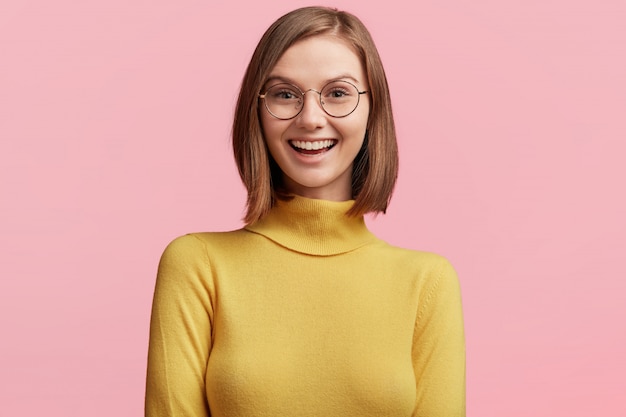 Free photo young woman with round glasses and yellow sweater