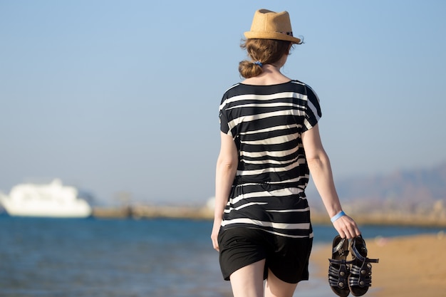 Free photo young woman with sandals in hands