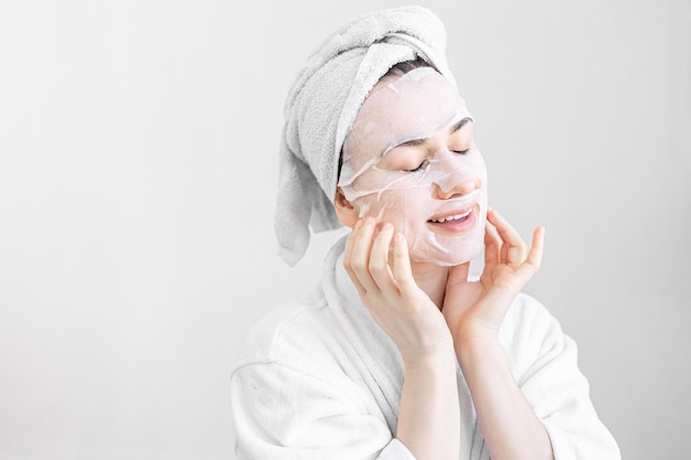 Young woman with sheet mask on her face spa procedure