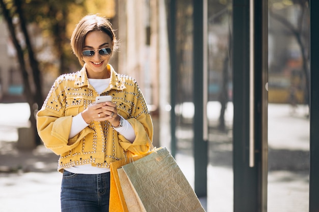 Free photo young woman with shopping bags in the city