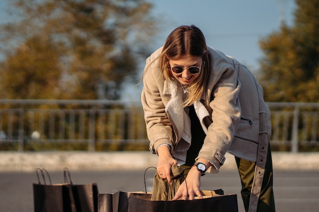 Young woman with shopping bags on parking