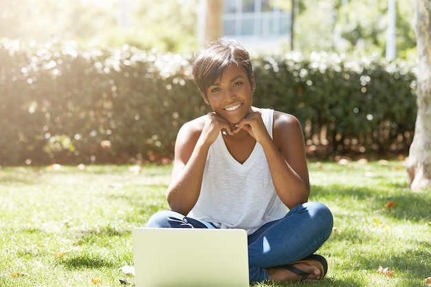 Young woman with short hair sitting in park