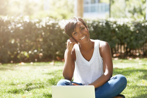 Young woman with short hair sitting in park