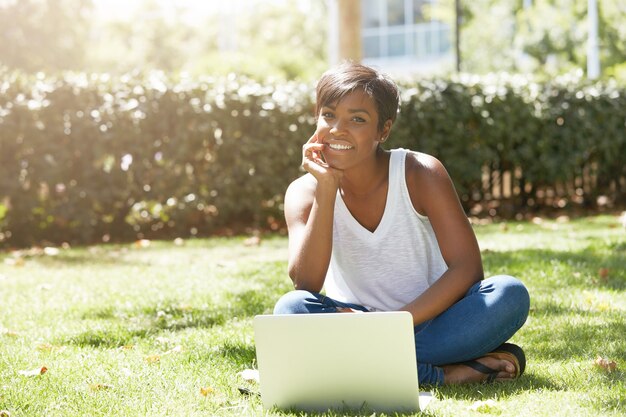 Young woman with short hair sitting in park