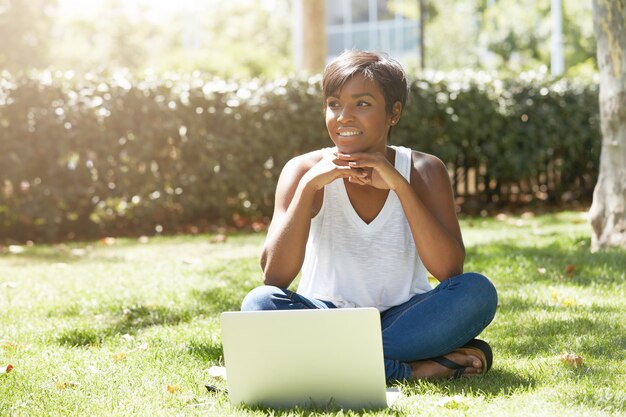 Young woman with short hair sitting in park