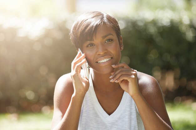 Young woman with short hair sitting in park