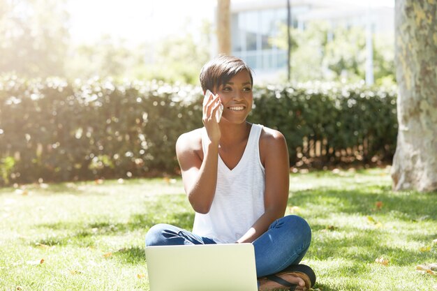 Young woman with short hair sitting in park