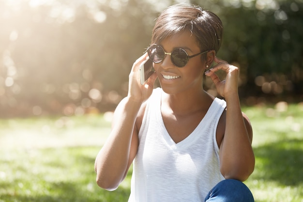 Young woman with short hair sitting in park