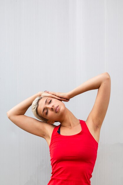 Young woman with short hair stretching outside