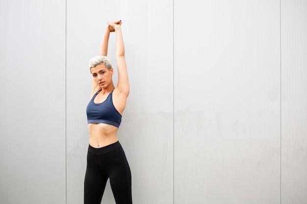 Free photo young woman with short hair stretching