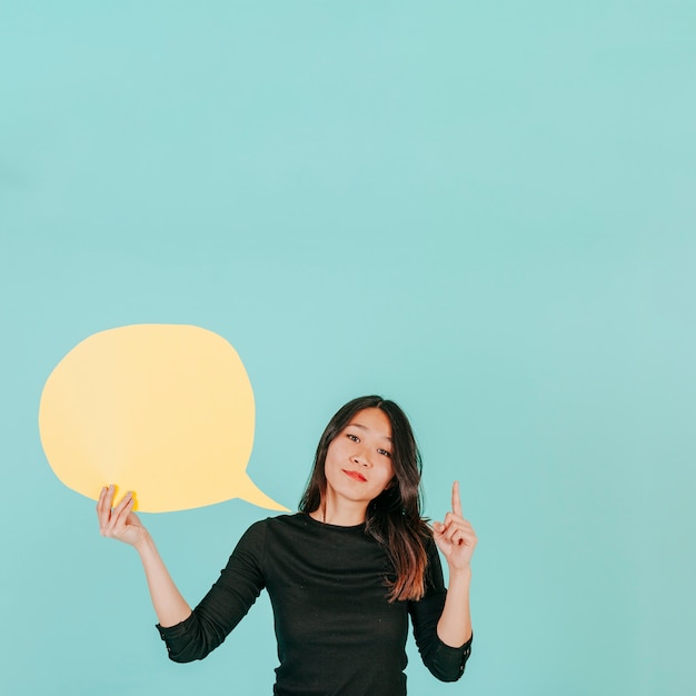 Young woman with speech bubble pointing up