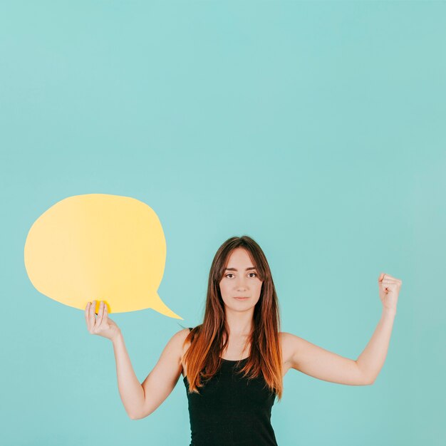 Young woman with speech bubble showing muscles