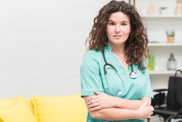 Young woman with stethoscope around her neck standing in hospital