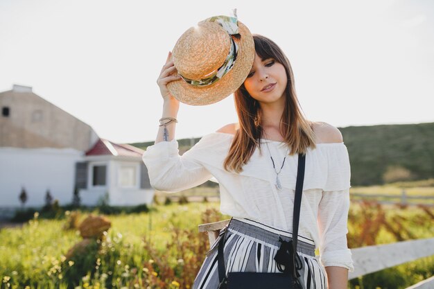 田舎で麦わら帽子を持つ若い女