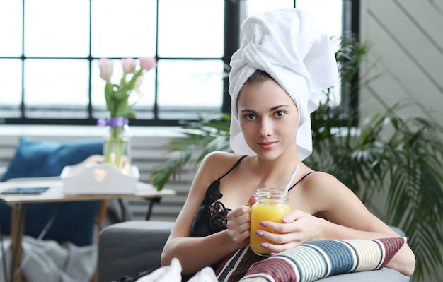 Young woman with towel on her head and orange juice