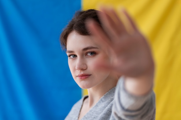 Giovane donna con bandiera ucraina dietro