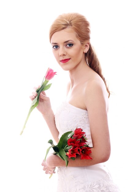 Молодая женщина с свадебным платьем и букетом