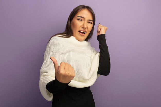 Young woman with white scarf happy and excited clenching fists 