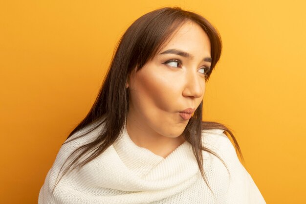 Young woman with white scarf looking aside confused 