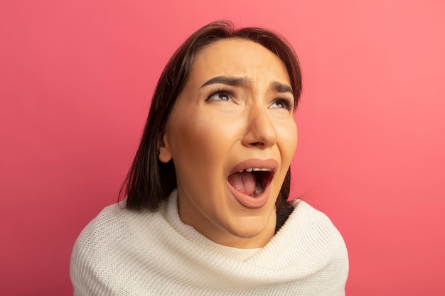 Free photo young woman with white scarf shouting with annoyed expression