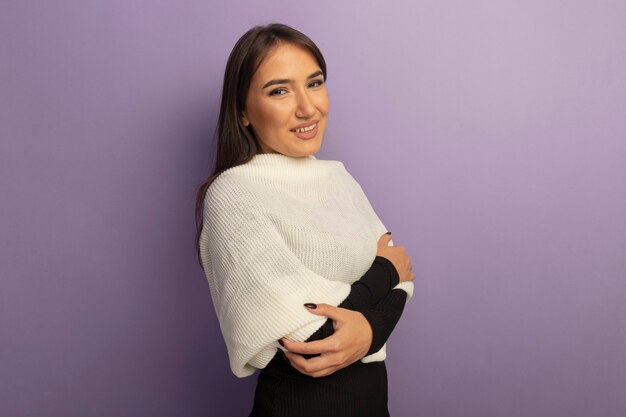 Free photo young woman with white scarf smiling cheerfully with arms crossed on chest