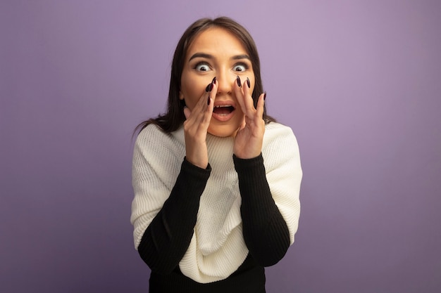 Free photo young woman with white scarf whispering with hands near mouth being amazed and surprised