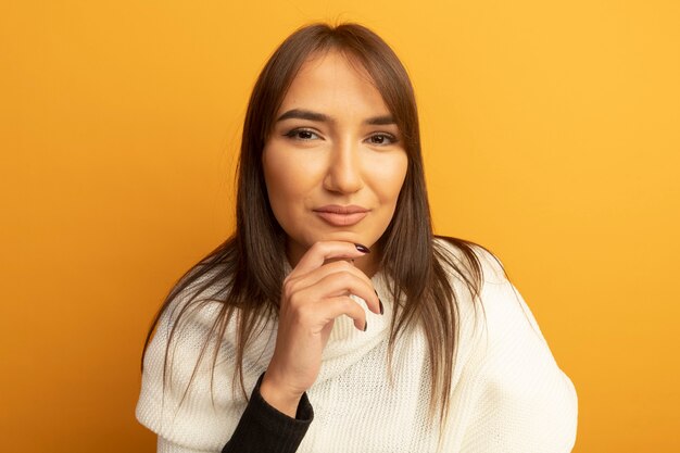 Young woman with white scarf with hand on chin thinking 