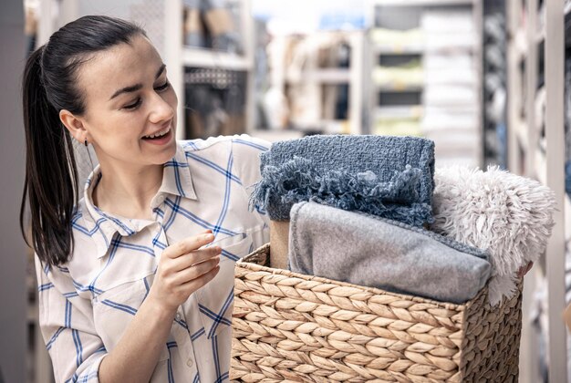 A young woman with a wicker basket full of blankets in a home improvement store