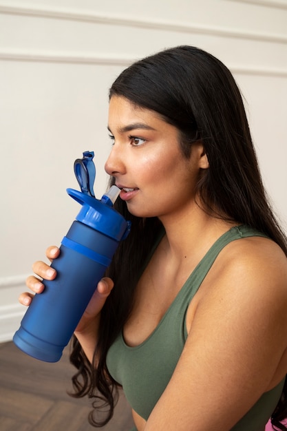 Foto gratuita giovane donna con elementi essenziali per lo yoga