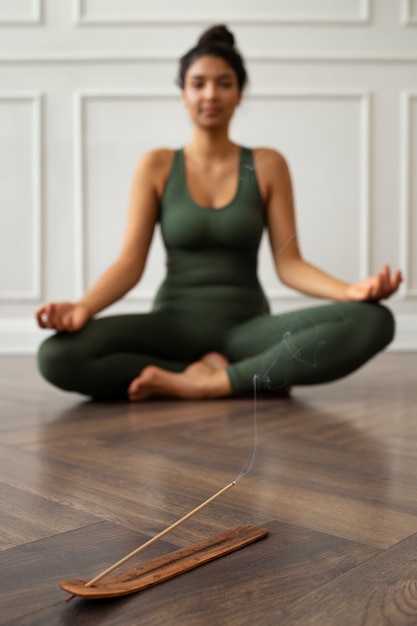 Бесплатное фото Молодая женщина с предметами первой необходимости йоги