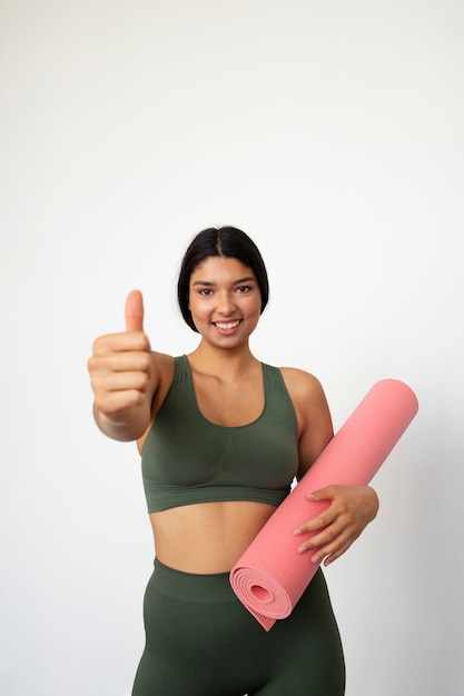 Giovane donna con elementi essenziali per lo yoga