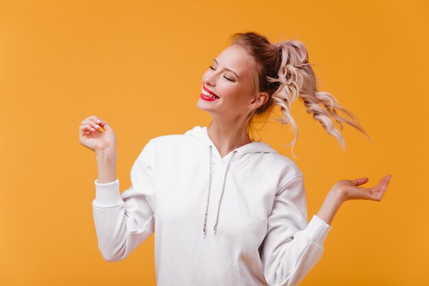 Young woman in wonderful mood laughs with her eyes closed