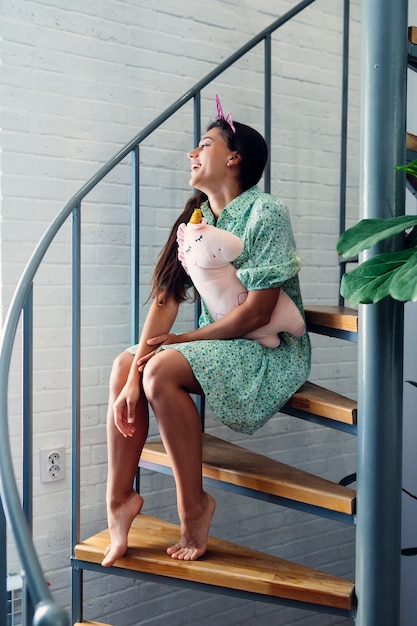 Free photo young woman on wooden stairs in modern house.