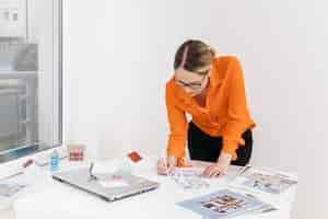 Free photo young woman working on blueprint on desk