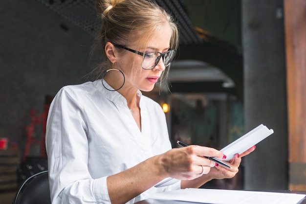 Young woman working on document in restaurant