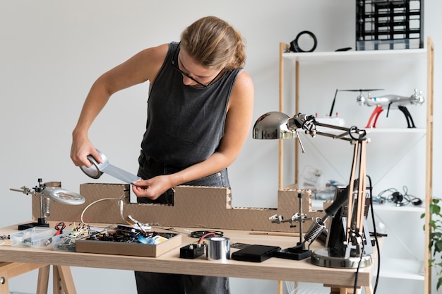 Молодая женщина, работающая в своей мастерской для творческого изобретения