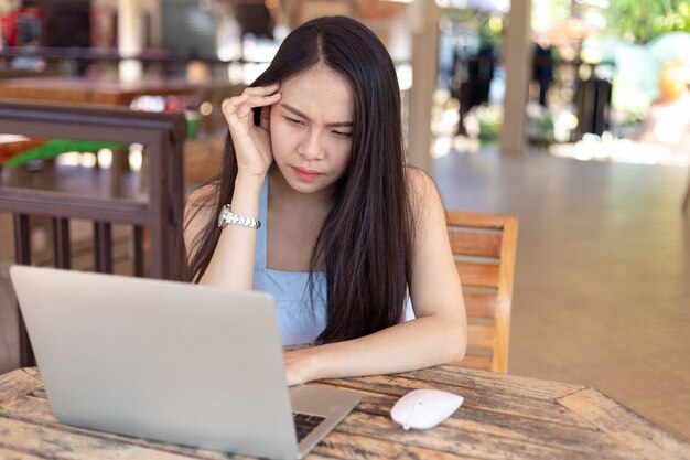 young woman working on laptop having a headache.